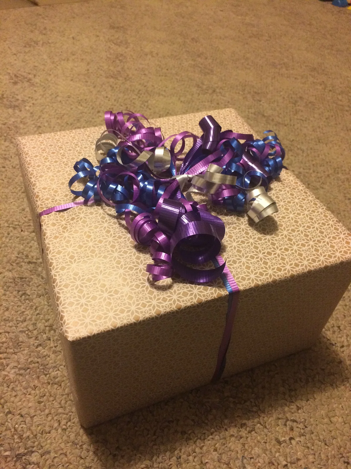 A hand-wrapped gift box with ribbon curls on top