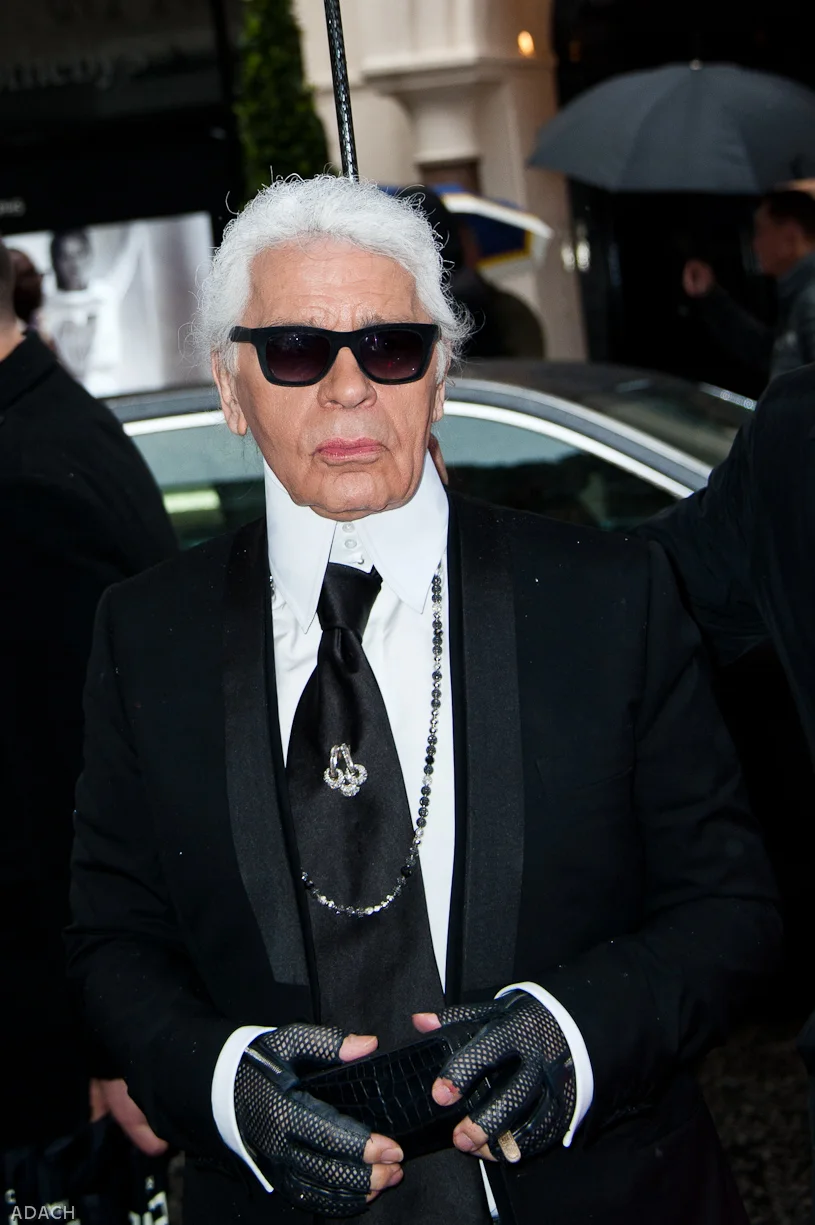 Karl Lagerfeld in his signature dark glasses, high collar and ponytail