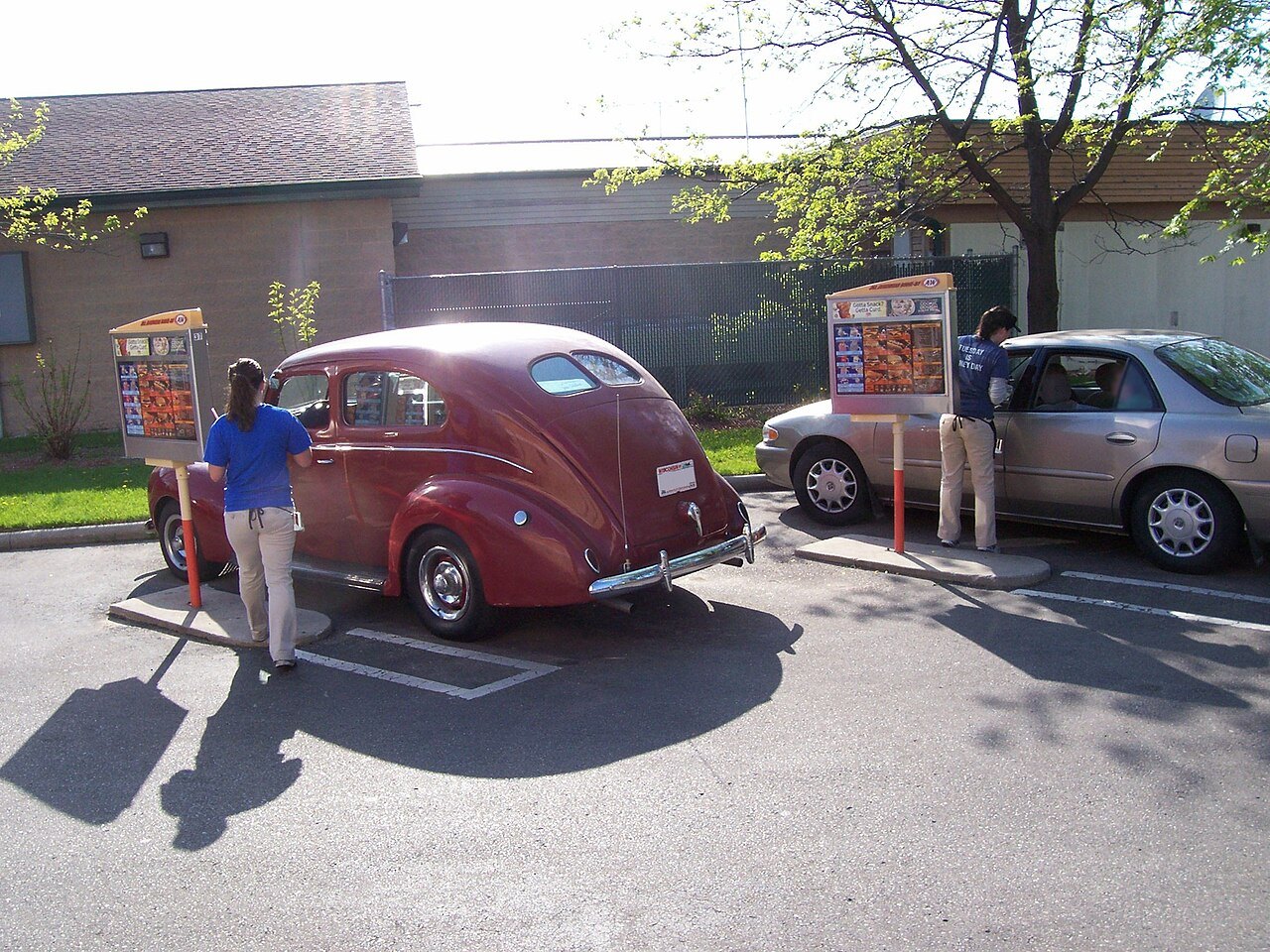 A carhop serving drivers at a drive-in restaurant