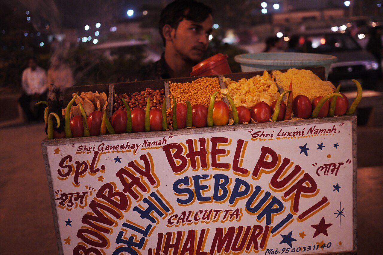 An Indian street-food stall at night serving bhelpuri