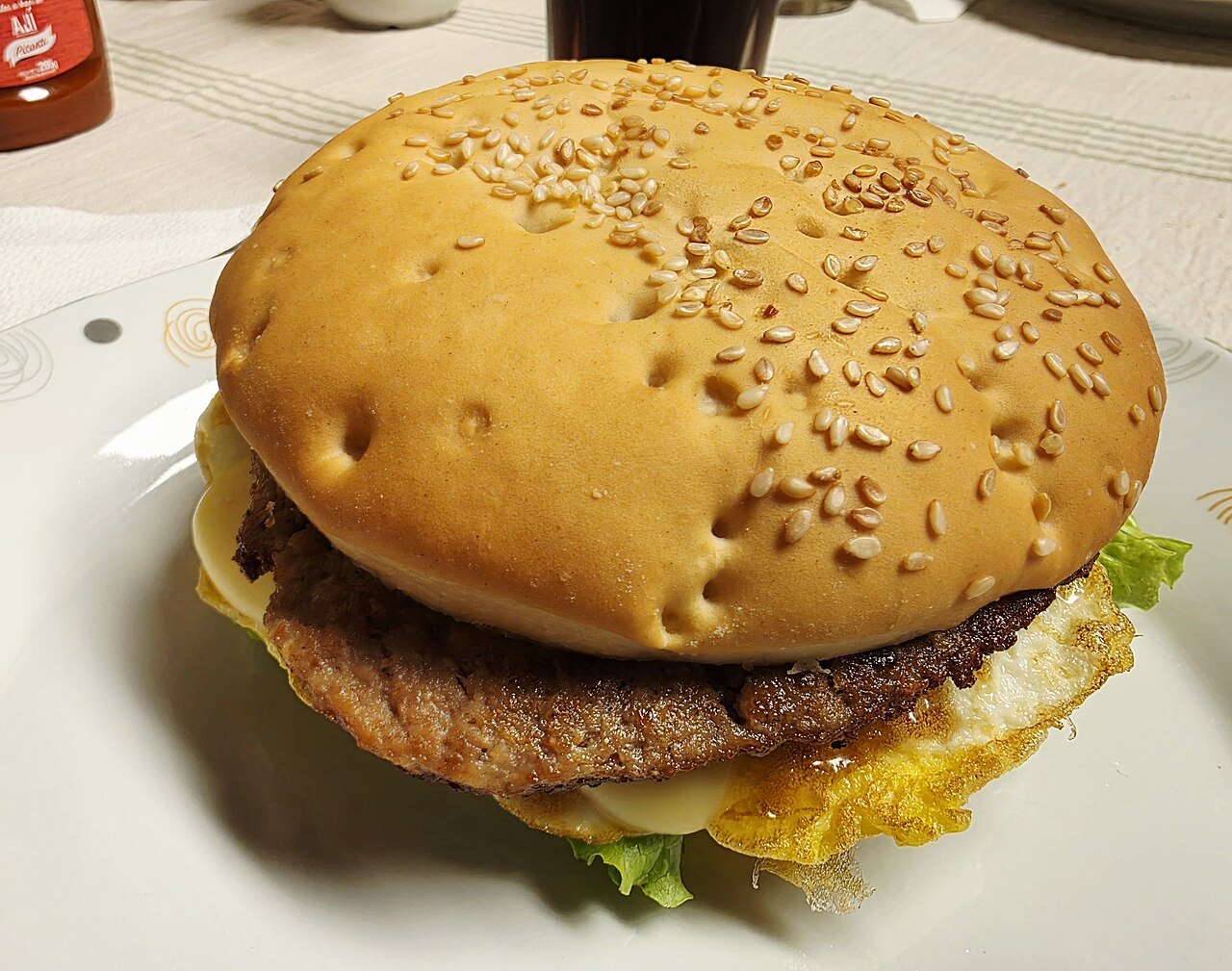 A beef hamburger in a sesame-seed bun