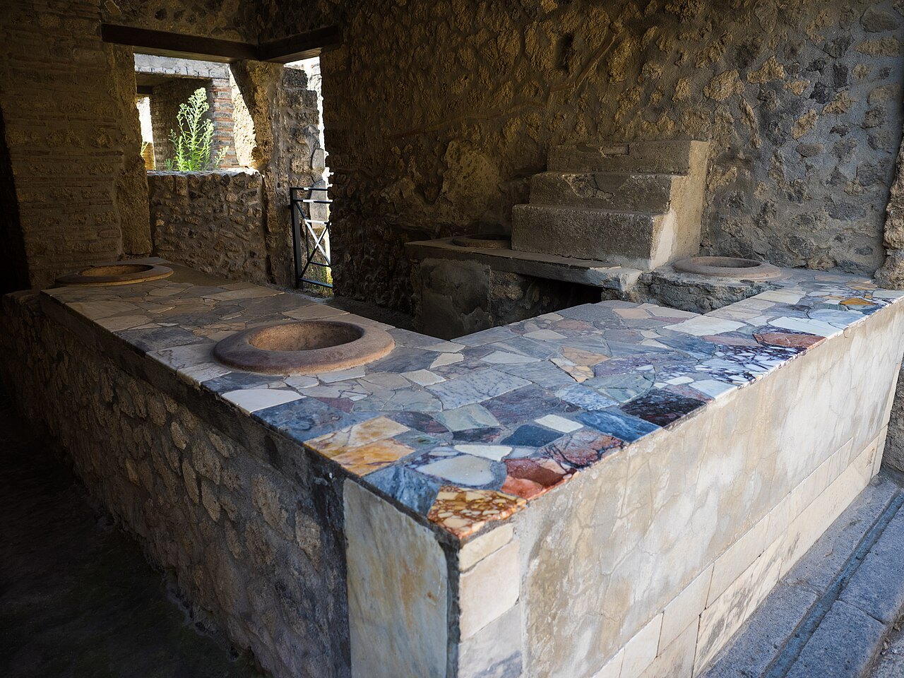 Ancient thermopolium counter with storage jars at Pompeii, Italy