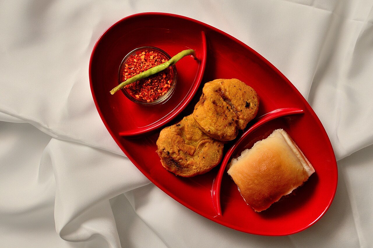 Vada pav served with chutney and a fried chilli