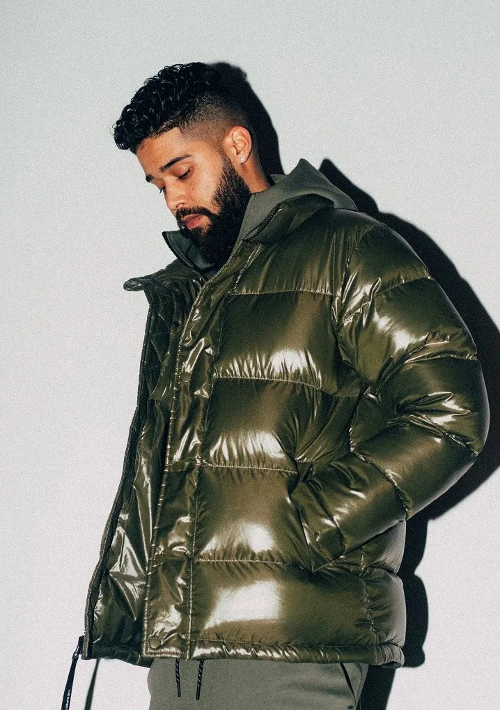 AP Dhillon posing in a green puffer jacket