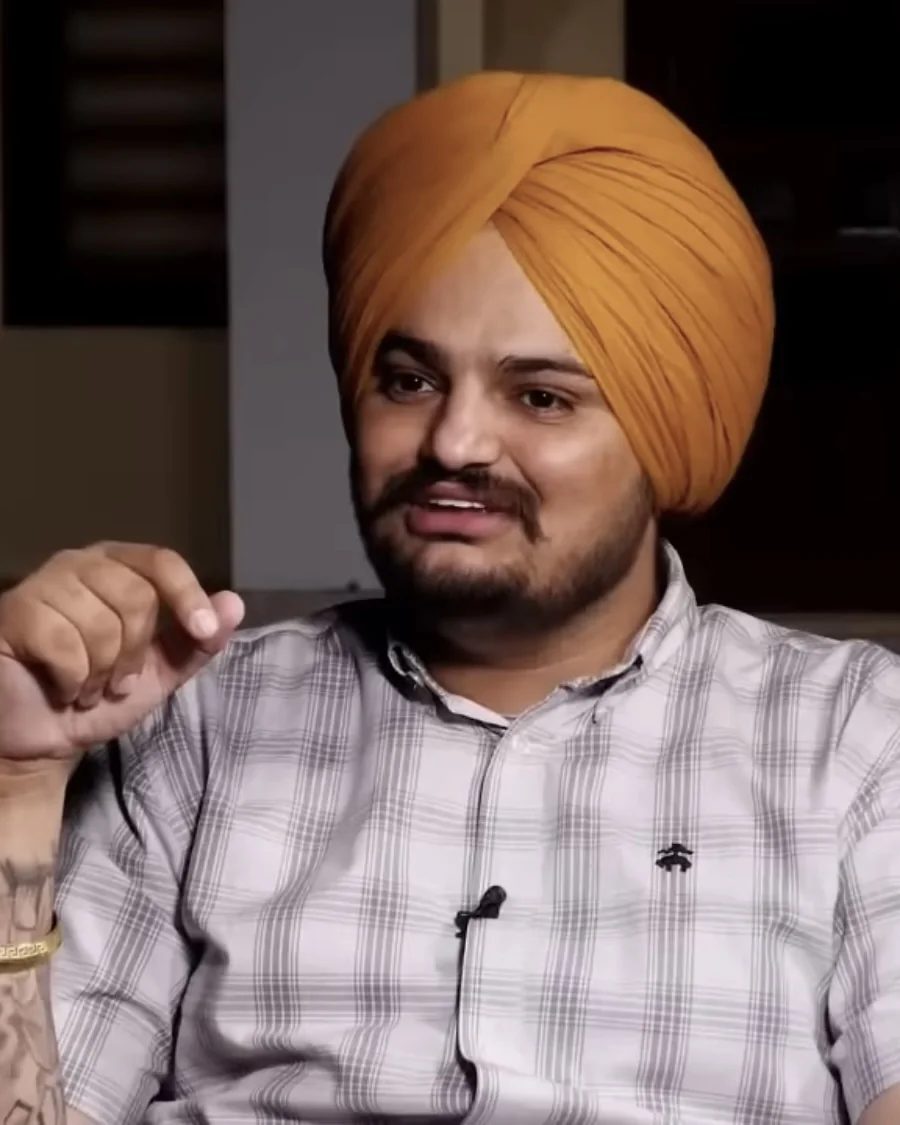 Sidhu Moose Wala in a check shirt and orange turban during an interview at Moosa in 2022